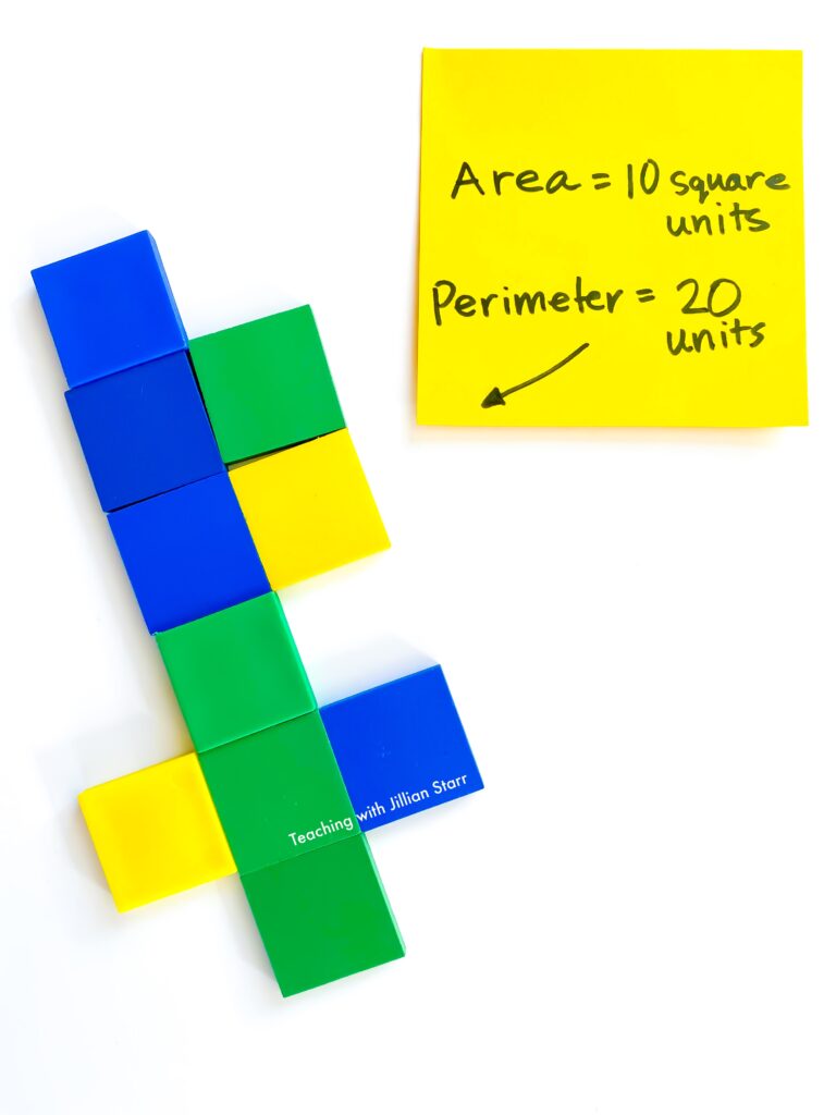 Square color tiles are arranged into a non-traditional shape with its area and perimeter marked on post-it notes. They are the perfect manipulative for introducing area and perimeter.