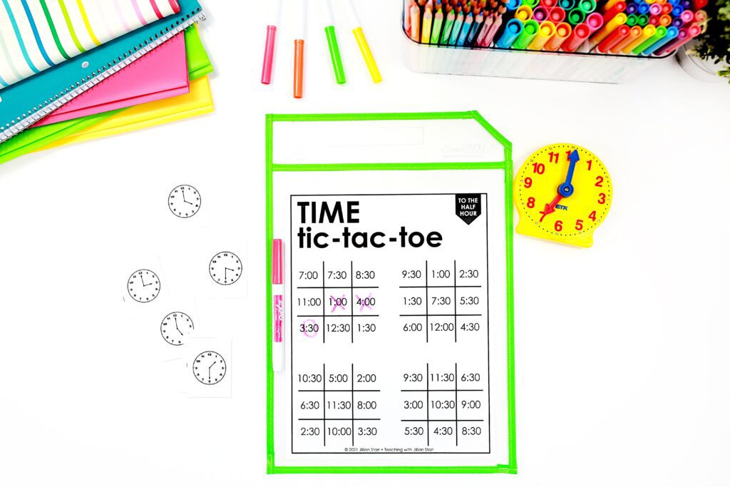 telling time to the half hour tic-tac-toe, with four boards showing digital clocks showing times to the half hour. Cards with analog clocks to the half hour are scattered next to it.
